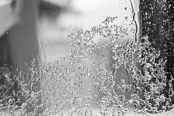 Ice and rain water on a glass window, frosty window pane