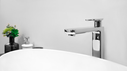 Luxury modern style faucet mixer on a white sink in a beautiful gray and white bathroom