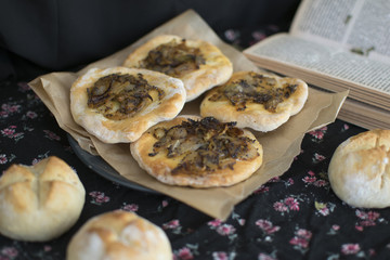 Traditional Polish onion cake. Salty cake with an onion. Fresh homemade rolls. Black background. Dark food photography. Vintage photo