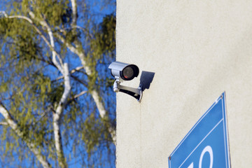 Kamera monitoringu CCTV zamontowana na ścianie budynku. - obrazy, fototapety, plakaty