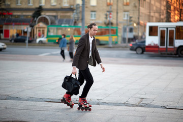 the guy rides on rollers after work. in a jacket and sports style. healthy lifestyle. on the street