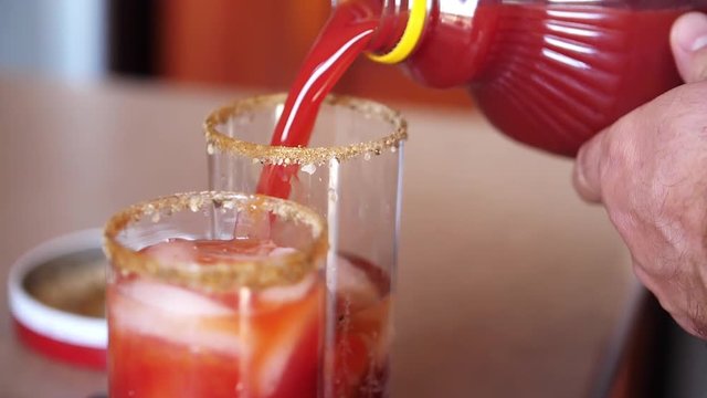 Slow motion shot of pouring tomato juice as an ingredient of a Bloody Mary alcoholic drink.