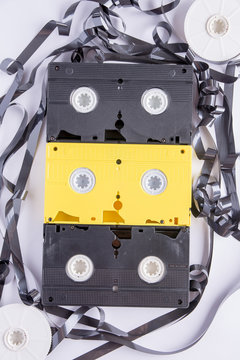 vhs cassettes and around them a tape of damaged one