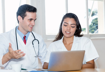 Caucasian doctor with latin american nurse working at hospital