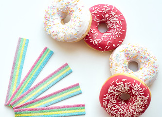 White and pink donuts and jelly candies on the white background isolated. Copy space.