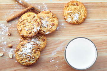 Cookies with peanuts and glass of milk on the wooden table. Copy space.