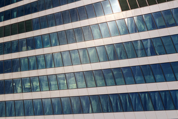 Glass facade of a modern office building close up on a sunny day