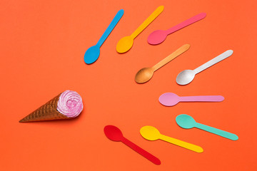 a horn with ice cream or with a cream and a lot of multicolored spoons aspire to ice cream