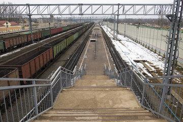 Railway station in winter and freight and passenger trains