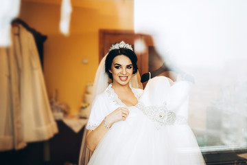 Naklejka premium Pretty bride dressing up before wedding ceremony