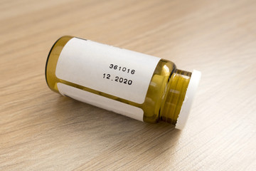 tablets in a closed jar on a light wooden table