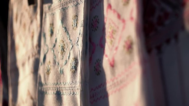 National Ukrainian rushnyk in warm sunlight. A symbol of Ukraine, traditional ethnic towel with hand embroidered ornament pattern. White cloth with multicolor needlework texture, close-up. 