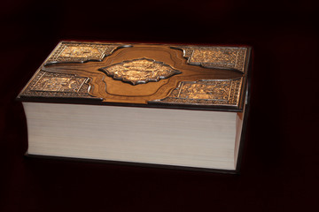Ancient book in luxurious binding isolated on black background