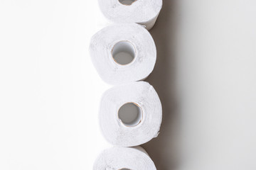 Directly above view of white recycled toilet paper rolls in a column on white background