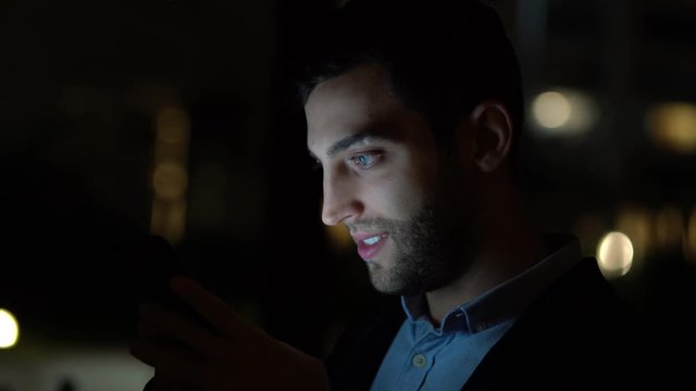Business man using mobile at nighttime