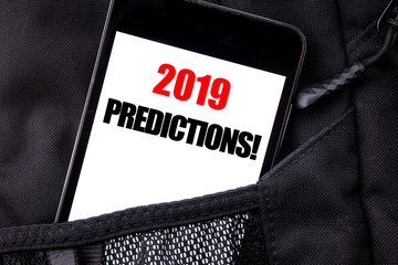 Handwritten text showing 2019 Predictions. Business concept writing for Forecast Predictive Written phone mobile phone, cellphone placed in the man front jeans pocket.