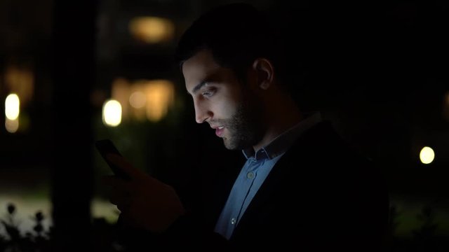 Business man using mobile at nighttime