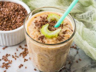 Smoothie with fennel, apple, carrots, celery and flax seeds on marble table background