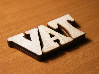 The word vat written with wooden letters background