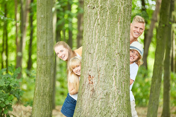 Glückliche Familie spielt verstecken