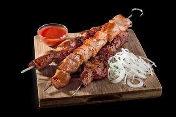 Traditional Russian shashlik on a barbecue skewer on black background