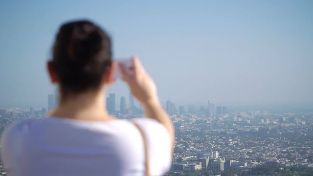 Professional video of woman taking picture of downtown in Los Angeles in slow motion 180fps  