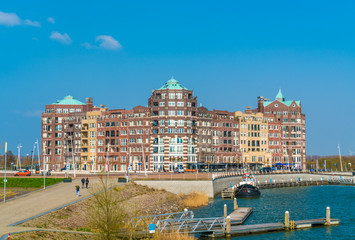 Fototapeta premium Lelystad, The Netherlands april 11 2018, tourist walking towards the buildings of the Lelystad Harbour