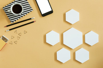 Creative desk with mock up hexagon shapes and phone for project. Concept of modern approach to management project. 