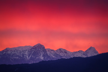 peak of mountains with red sunset and stormy weather backgrounds