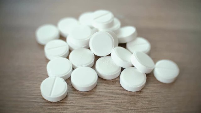 Pile of round white tablets on the table.