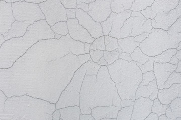 Texture of white dirty cracked wall. Small straight cracks. Direct fracture on painted surface. Cells fissure
