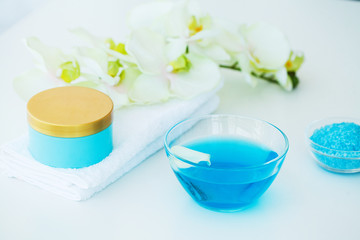 Blue Bath Salt, Body Cream and Shells For Spa on White Table Background