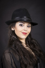 Beautiful young girl in black tunic, black gloves and black hat.