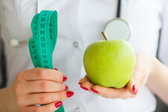 Diet. Female Nutritionist and Holding an Apple and a Measure Tape. New Start For Healthy Nutrition, Body Slimming, Weight Loss. Cares About Body.