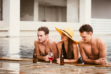 Group of friends enjoying vacation in summer time. Young people having fun in swimming pool