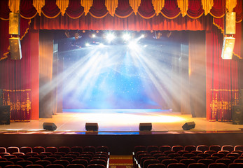 The stage of the theater illuminated by spotlights from the auditorium