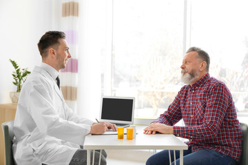 Obraz premium Male doctor consulting patient in clinic