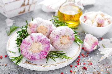 Fototapeta na wymiar Garlic. Fresh garlic, oil and rosemary on kitchen table