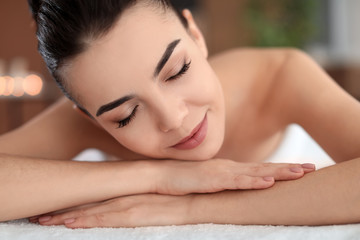Young woman lying on massage table in spa salon