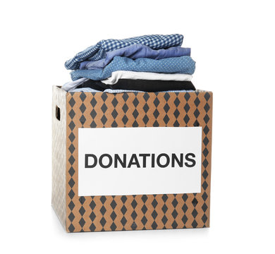Donation box with clothes on white background