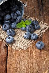Blueberry on wooden table background. Ripe and juicy fresh picked blueberries closeup. Berries closeup with copy space