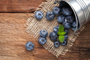 Blueberry on wooden table background. Ripe and juicy fresh picked blueberries closeup. Berries closeup with copy space