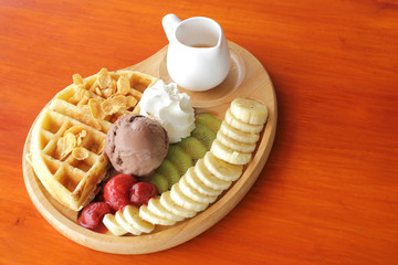 waffle and chocolate ice cream with fresh fruit and syrup