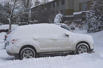 Cars and houses in a residential area covered in heavy winter snow