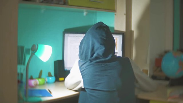Hacker man programmer in the hood using computer for hack information and data from user account. orange color web indoors social media online