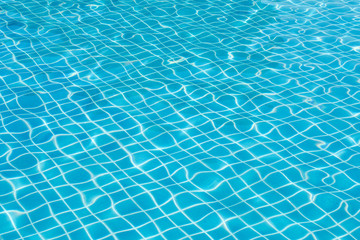 Bright water surface and ripple wave in swimming pool with blue tile