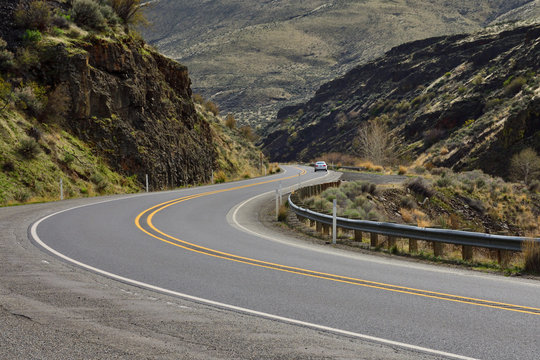 A Car Passing Through The Yakima River Canyon Road