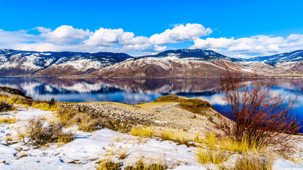 Snow Covered Mountains surrounding Kamloops Lake in central British Columbia, Canada on a cold and crisp Winter Day under a blue sky