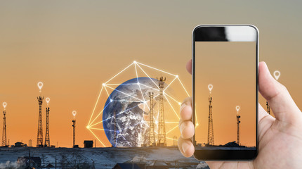 Hand holding mobile smartphone, and telecommunication towers with location signs and global network...