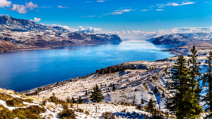 Obraz premium Snow Covered Mountains surrounding Kamloops Lake in central British Columbia, Canada on a cold and crisp Winter Day under a blue sky